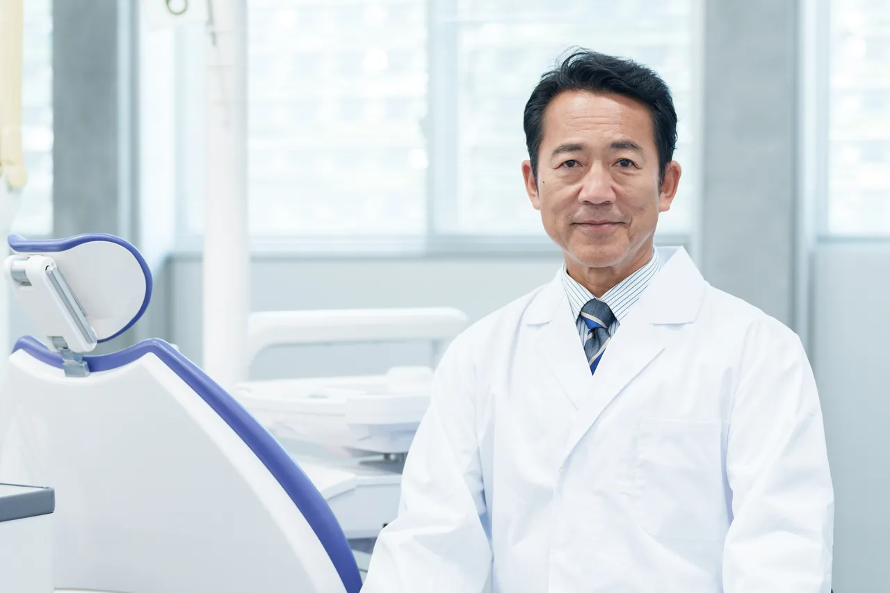 診療室に立つ白衣の歯科医