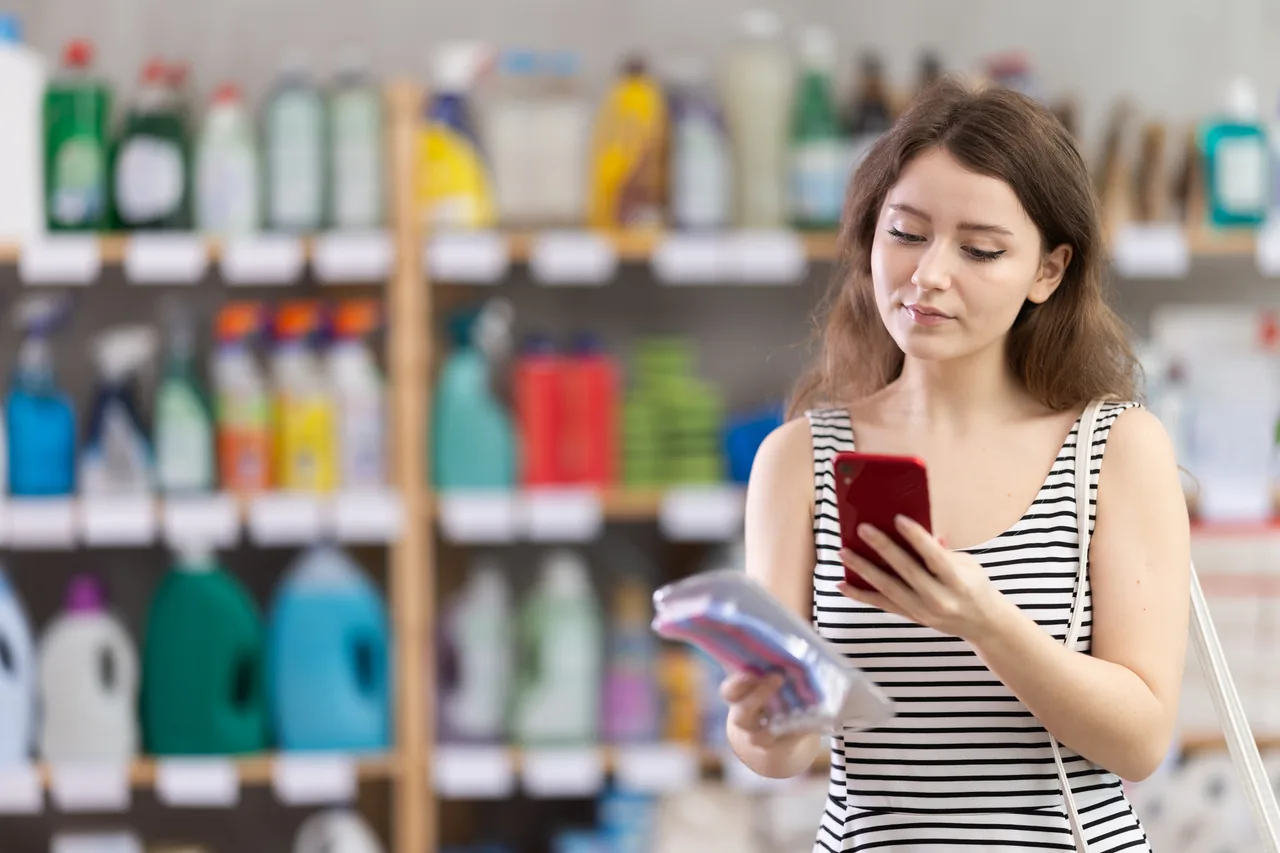 店内で商品を手にスマートフォンを見る海外からのお客様