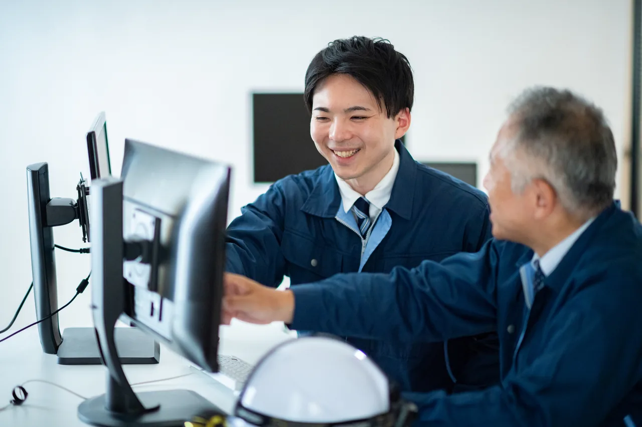 モニターを見ながら話す製造業の社員
