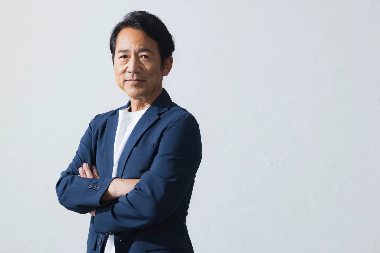 腕を組んで立つ代表者